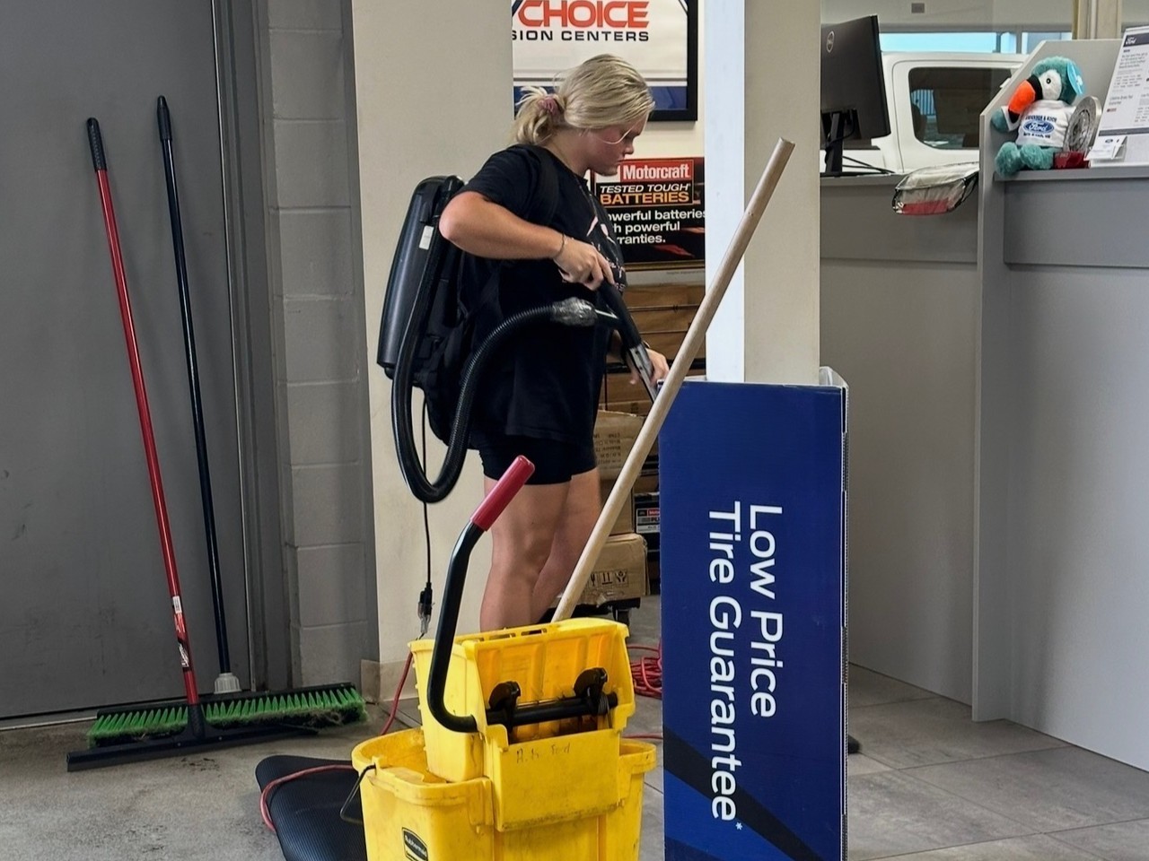 Le Vvintre team member cleaning floors in a commercial service center